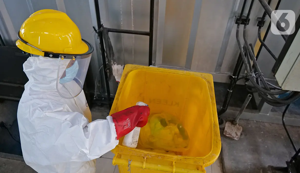 Petugas membersihkan tempat sampah dengan cairan disinfektan usai melakukan proses pembakaran limbah medis ke dalam incinerator di RSCM Jakarta, Jumat (26/6/2020). Volume limbah medis infeksius di seluruh Indonesia hingga 8 Juni 2020 mencapai lebih dari 1.100 ton. (Liputan6.com/Herman Zakharia)