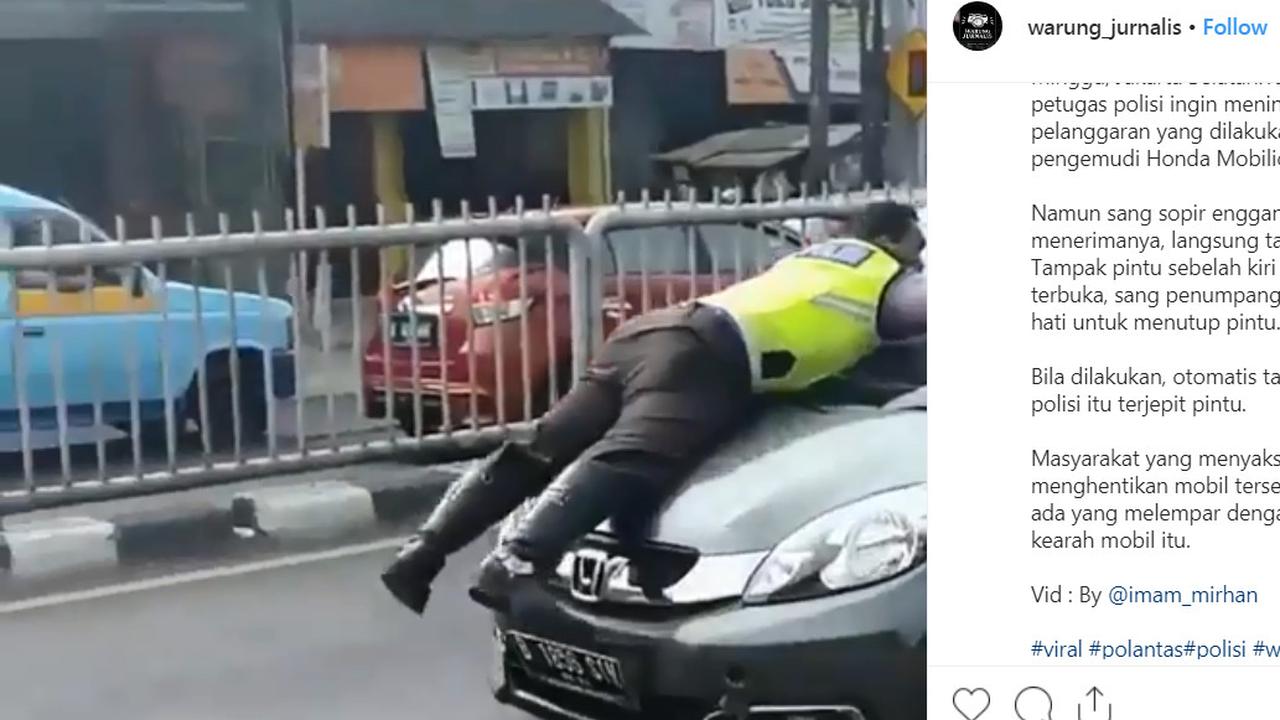 Polisi menempel di kap mobil yang melaju