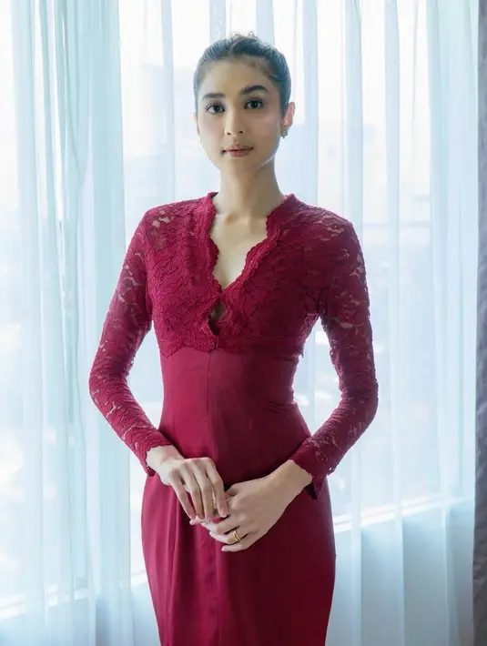 Saat akad nikah sahabatnya, Mikha mengenakan dress brokat warna merah merona yang simple. Rambutnya ditata updo, sementara wajahnya dipulas makeup natural. [@miktambayong]
