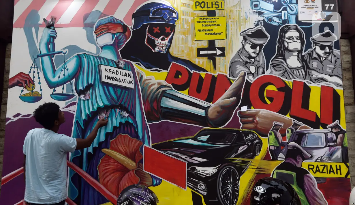 Warga memperhatikan mural berisi kritik terhadap kinerja polisi di Lapangan Bhayangkara Mabes Polri, Jakarta, Minggu (31/10/2021). Sejumlah mural berisi kritik terhadap polisi dipamerkan usai mengikuti ajang Mural Festival 2021 Piala Kapolri 2021. (Liputan6.com/Helmi Fithriansyah)