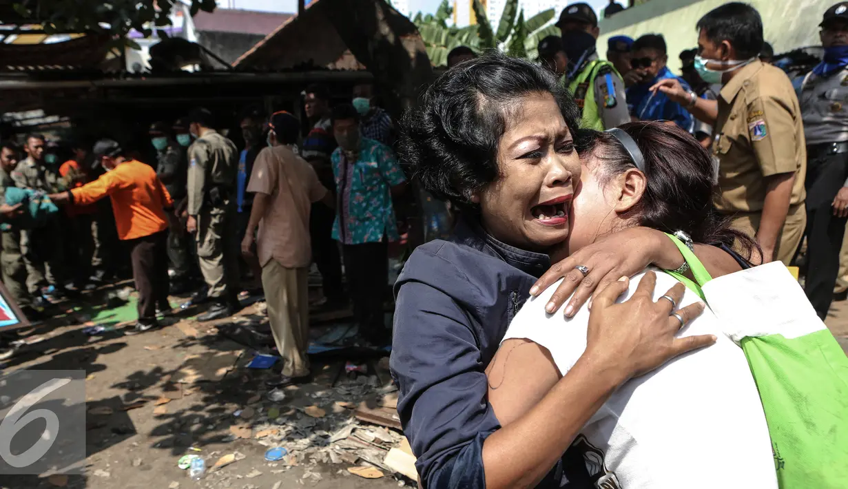 Salah satu penghuni menangis histeris saat penggusuran terjadi di Rawasari Selatan, Jakarta, Kamis (23/7/2015). Tampak upaya petugas saat melakukan pengusuran di  Rawasari Selatan. (Liputan6.com/Faizal Fanani)