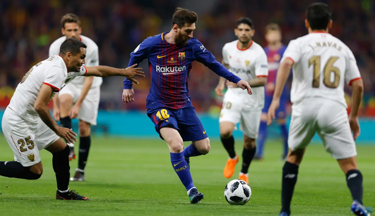 Penyerang Barcelona, Lionel Messi berusaha melewati beberapa pemain Sevilla saat bertanding pada final Copa del Rey di stadion Wanda Metropolitano di Madrid (21/4). Barcelona menang 5-0.  (AP Photo / Paul White)