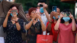 Warga mengambil foto dan video ketika otoritas Cina bersiap memasuki Konsulat Amerika Serikat (AS) di Chengdu, Senin (27/7/2020). Bendera Amerika Serikat di Konsulat AS Chengdu diturunkan Senin (27/7), menandai ditutupnya kantor perwakilan Negeri Paman Sam di kota itu. (AP Photo/Ng Han Guan)