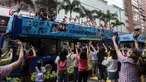 Anggota delegasi Olimpiade Hong Kong mengibarkan bendera selama parade bus, setelah Olimpiade Tokyo 2020, di Hong Kong, Kamis (19/8/2021). Hong Kong yang memiliki 46 atlet perwakilan pada Olimpiade Tokyo 2020 berhasil mengumpulkan satu emas, dua perak dan tiga perunggu. (ISAAC LAWRENCE/AFP)