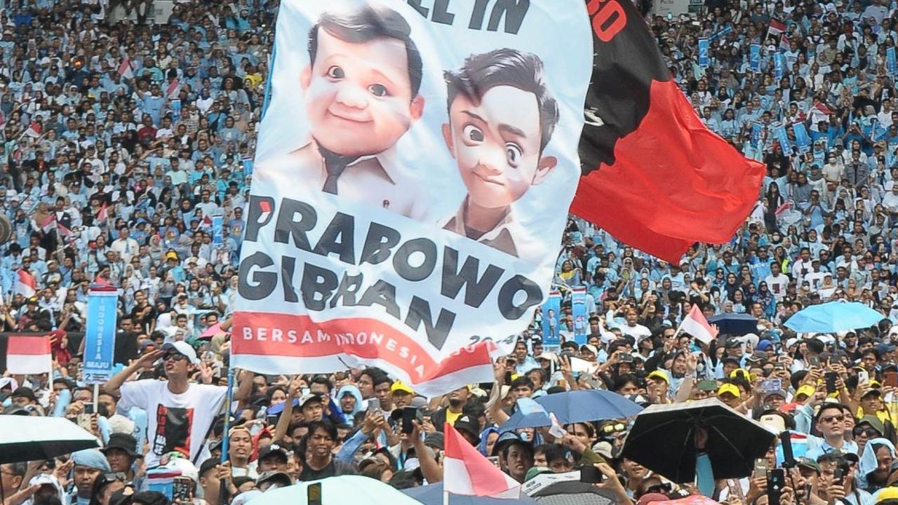 Tampak massa pendukung Prabowo-Gibran membentangkan spanduk saat menghadiri Kampanye Akbar di GBK. Foto: merdeka.com / Imam Buhori<br>