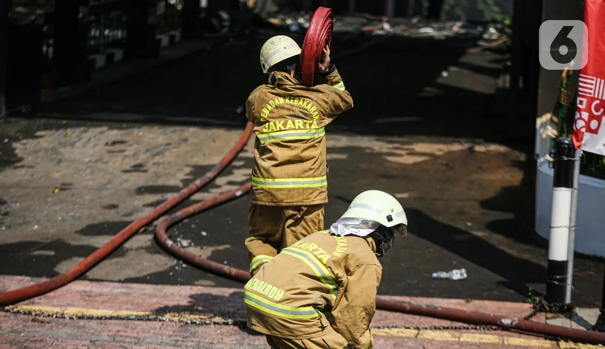 Petugas pemadam kebakaran usai melakukan pendingan di Gedung Kejaksaan Agung RI yang terbakar, Minggu (23/8/2020). Kebakaran di gedung Kejaksaan Agung pada Sabtu (22/8) malam akhirnya padam dan kini bangunan tersebut menyisakan bagian hitam legam. (Liputan6.com/Faizal Fanani)