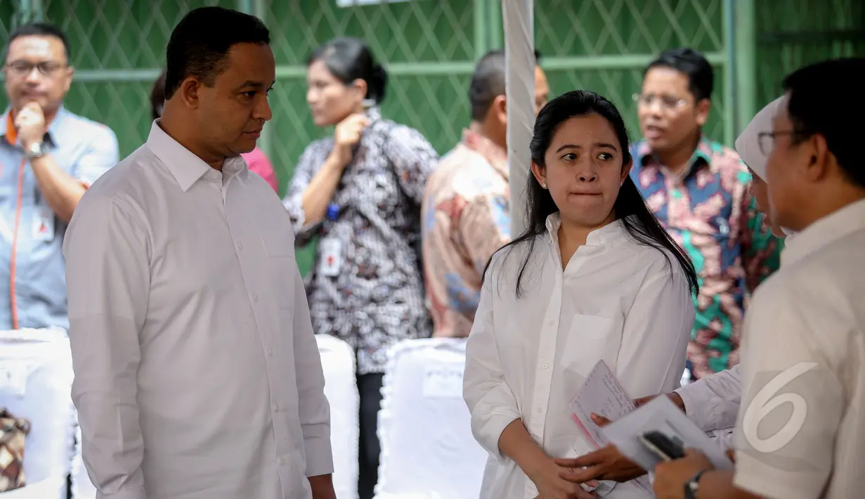Menko PMK Puan Maharani (kedua kiri) dan Mendikbud Anies Baswedan saat pembagian Kartu Indonesia Sehat (KIS), Kartu Indonesia Pintar dan Kartu Keluarga Sejahtera (KKS) kepada warga di Penjaringan, Jakarta, Rabu (13/5). (Liputan6.com/Faizal Fanani)