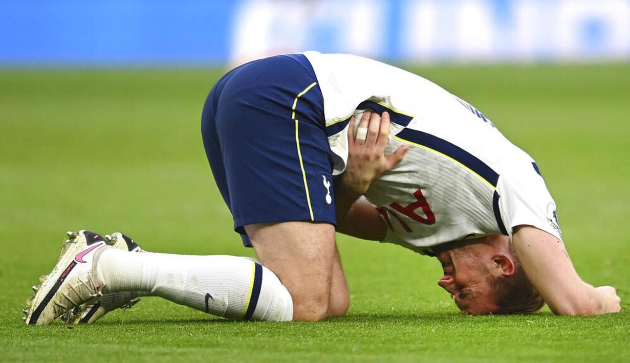 Striker Tottenham Hotspur, Harry Kane, memegang perutnya saat melawan Leicester City pada laga Liga Inggris, Minggu (20/12/2020). Spurs menyerah dengan skor 2-0. (Andy Rain/POOL/AP)