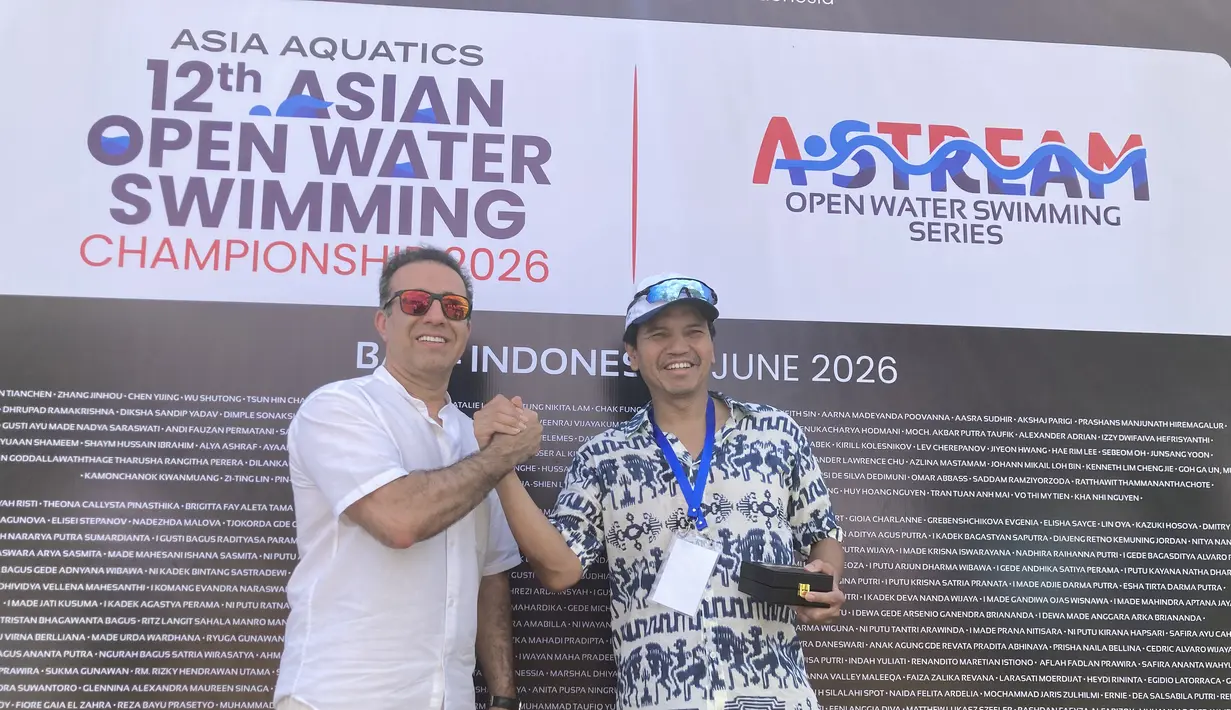 Executive Director Asia Aquatics Farid Fattahian (kanan) saat memberikan medali kepada Ketua Harian PB Akuatik Indonesia Harlin E. Rahardjo saat 12th Asian Open Water Swimming Championship 2026 di Pantai Jimbaran pada Minggu (14/6/2026). (Bola.com/Alit Binawan)
