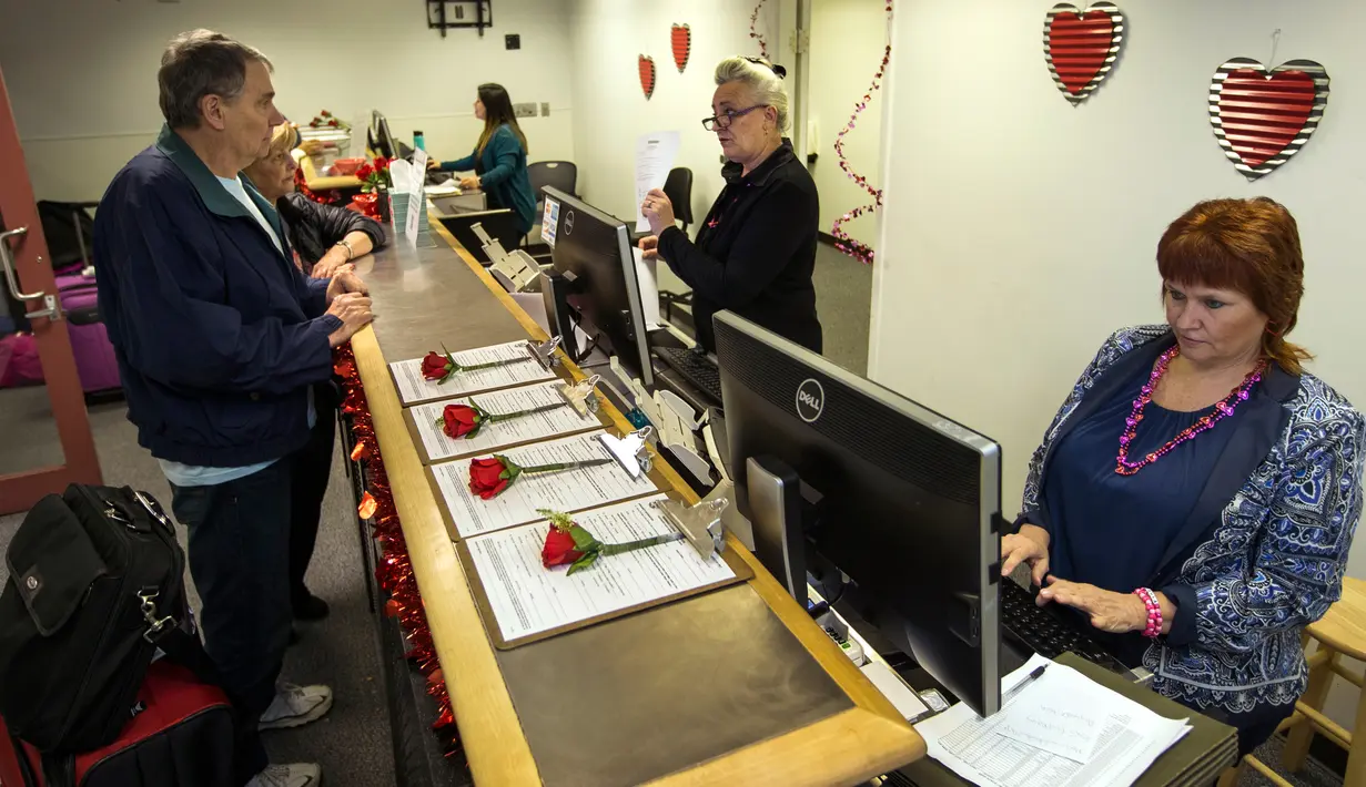 Pegawai Clark County Clerk's melayani pengunjungnya di Bandara Internasional McCarran di Las Vegas (12/2). Menjelang hari valentine para pasangan ingin mendaftarkan diri mereka sebagai pengantin yang menikah pada hari kasih sayang itu. (AFP/L.E. Baskow)