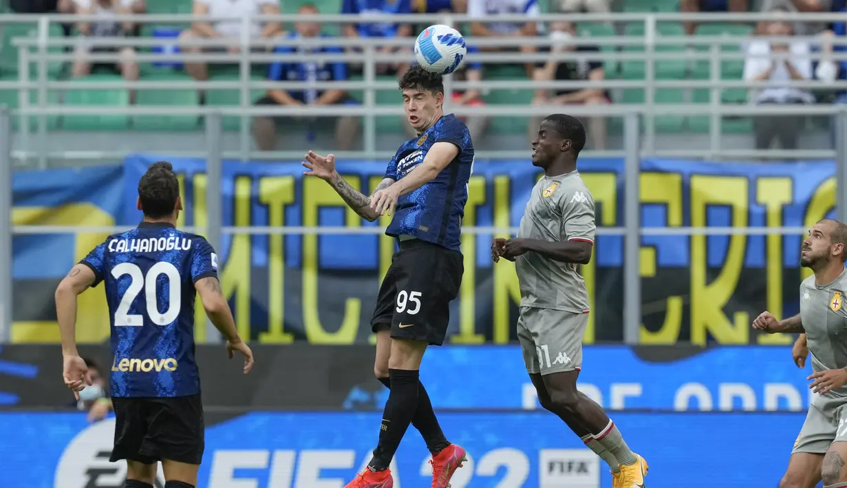 Bek Inter Milan, Alessandro Bastoni berebut bola udara dengan pemain Genoa, Yayah Kallon pada pertandingan perdana Liga Serie A Italia di stadion San Siro di Milan, Italia, Sabtu (21/8/2021). Inter Milan menang telak atas Genoa dengan skor 4-0. (AP Photo/Antonio Calanni)