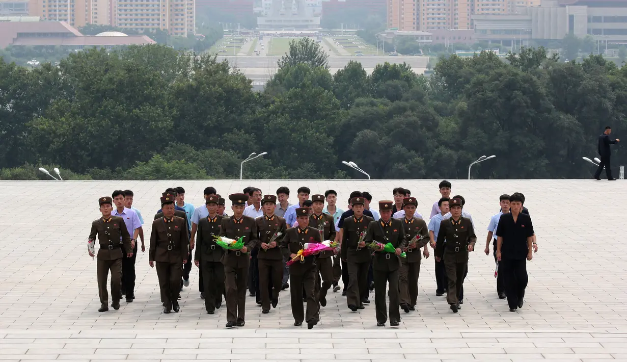 Tentara membawa bunga saat akan memberi penghormatan kepada patung pemimpin Korea Utara Kim Il Sung dan Kim Jong Il dalam peringatan berakhirnya Perang Dunia II dan pembebasan dari kolonial Jepang di Pyongyang, Korut, Rabu (15/8). (AP Photo/Ng Han Guan)