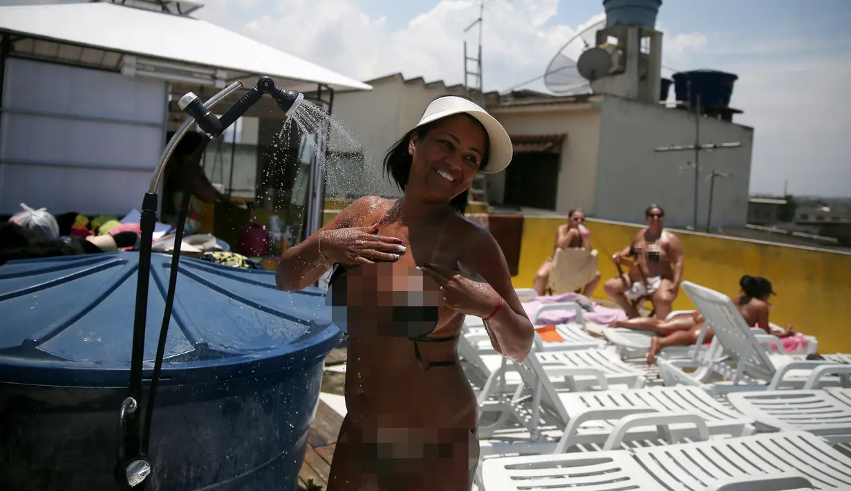 Seorang pengunjung mandi setelah berjemur di spa Erika Bronze di Rio de Janeiro, Brasil (22/11). Mereka berjemur untuk mendapatkan tanda bikini yang sempurna di tubuhnya, atau yang biasa disebut dalam bahasa Portugis Marquinha. (Reuters/Pilar Olivares)