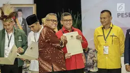 Ketua KPU Arief Budiman, memberikan berita acara parpol kepada Sekjen PDI Perjuangan Hasto Kristiyanto usai pengambilan nomor urut peserta pemilu 2019 di KPU, Jakarta, Minggu (18/2). 14 parpol lolos jadi peserta pemilu 2019.(Liputan6.com/Faizal Fanani)