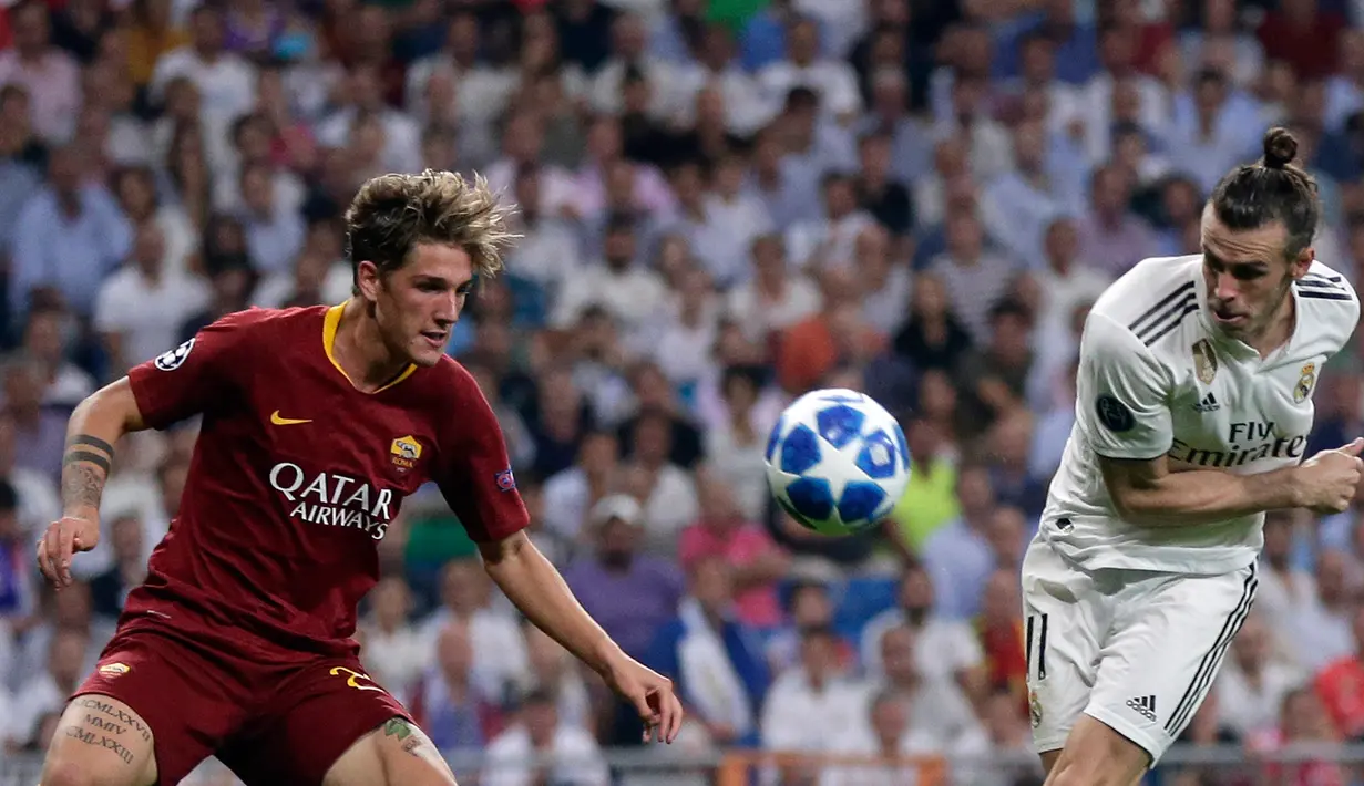 Gelandang Real Madrid, Gareth Bale (kanan) berebut bola dengan gelandang AS Roma Nicolo 'Zaniolo pada pertandingan Grup G Liga Champions di Stadion Santiago Bernabeu, Madrid, Spanyol, Rabu (19/9). Madrid membantai Roma 3-0. (AP Photo/Manu Fernandez)