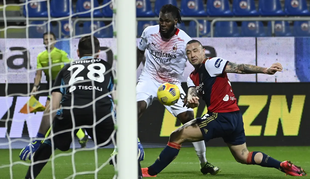 Gelandang AC Milan, Franck Kessie (tengah) menembak bola dari kawalan gelandang Cagliari Radja Nainggolan pada pertandingan Liga Serie A Italia di Sardegna Arena, Selasa (19/1/2021). Dengan kemenangan ini, AC Milan masih kokoh di puncak klasemen dengan 43 poin. (AFP/Alberto Pizzoli)