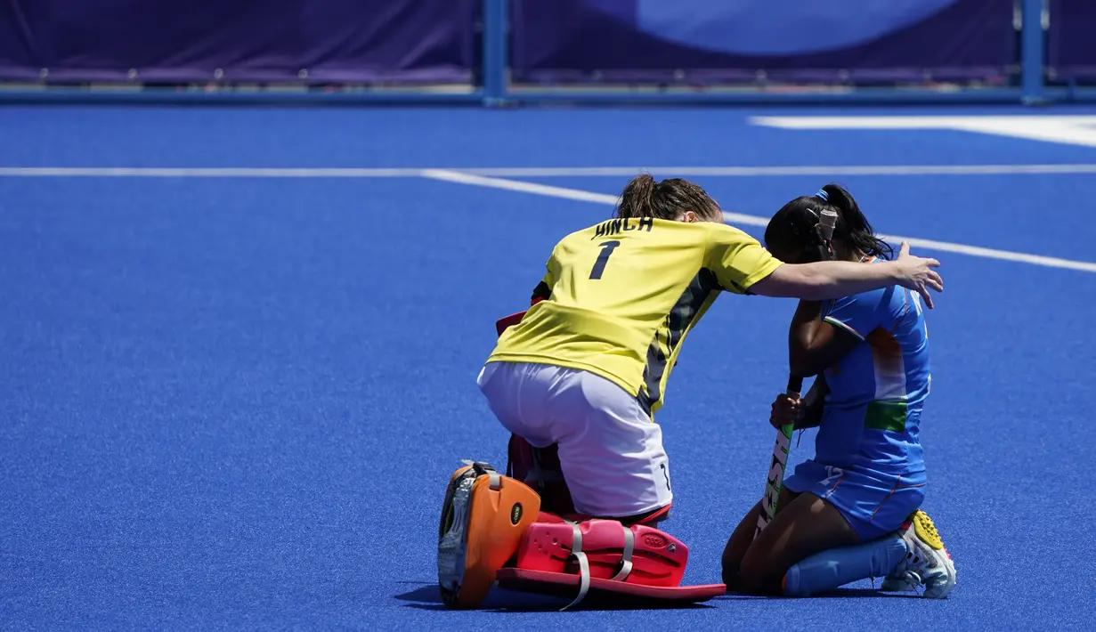 Atlet Inggris Claire Hinch (1) menghibur atlet India Neha Neha (kanan) setelah memenangkan medali perunggu hoki lapangan putri Olimpiade Tokyo 2020 di Tokyo, Jepang, 6 Agustus 2021. Inggris menang 4-3. (AP Photo/John Minchillo)