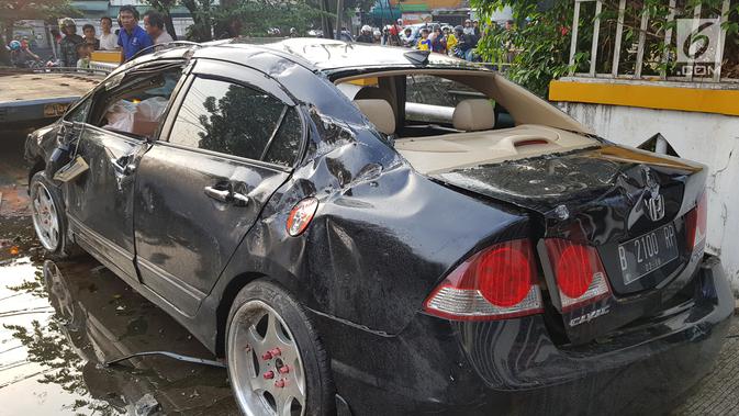 Kondisi sebuah mobil yang mengalami kecelakaan tunggal di kawasan Pasar Minggu, Jakarta Selatan, Sabtu (8/6/2019). Mobil yang nyaris tercebur sungai itu dikendarai seorang pemuda yang nekat melakukan aksi kebut-kebutan saat jalanan ibu kota lengang. (Liputan6.com/Herman Zakharia)