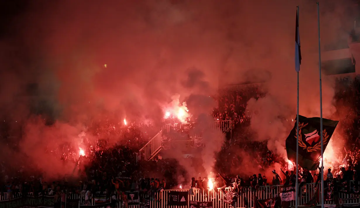 Suporter PSS Sleman menyalakan flare saat melawan Semen Padang pada laga Liga 2 di Stadion Pakansari, Jawa Barat, Selasa (4/12). PSS menang 2-0 atas Semen Padang. (Bola.com/M. Iqbal Ichsan)