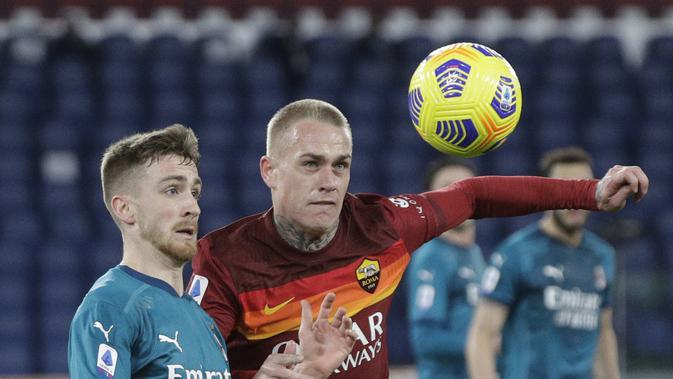 Gelandang AC Milan, Alexis Saelemaekers berebut bola dengan bek AS Roma,  Rick Karsdorp pada pertandingan Liga Serie A Italia di stadion Olimpiade, Italia,Senin (1/3/2021). Hasil ini membuat AC Milan menempel ketat rival mereka Inter Milan yang berada di puncak klasemen. (AP Photo/Gregorio Borgia)