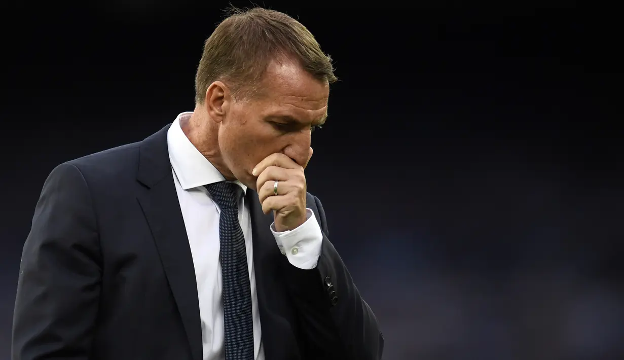 Pelatih Leicester City, Brendan Rodgers, tertunduk usai timnya dikalahkan Everton pada laga Premier League pekan ke-32 di Goodison Park, Kamis (2/7/2020) dini hari WIB. Leicester City kalah 1-2 atas Everton. (AFP/Peter Powell/pool)