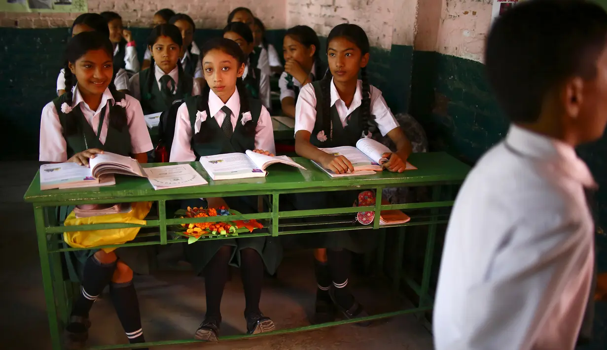 Mantan Dewi Nepal atau Kumari, Matina Shakya (tengah) duduk di kelas pada hari pertama sekolahnya di Kathmandu (9/10). Setelah pubertas Matina Shakya harus pensiun menjadi sosok dewi hidup yang disembah banyak orang di Nepal. (AFP Photo/Gopen Rai)