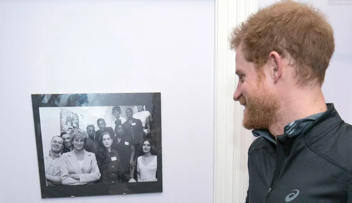 Pangeran Harry, melihat foto almarhum ibunya,  Putri Diana setelah tiba di badan amal Depaul di London,Inggris, (26/1). Pangeran Harry bersama relawan dan tunawisma berlari selama 17 menit dalam amal ini. (Geoff Pugh, Foto Renang via AP)
