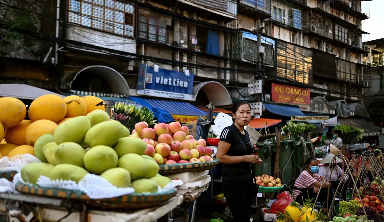 Seorang penjual buah menunggu pelanggan di sepanjang jalan di Hanoi (26/8/2020). (AFP Photo/Manan Vatsyayana)