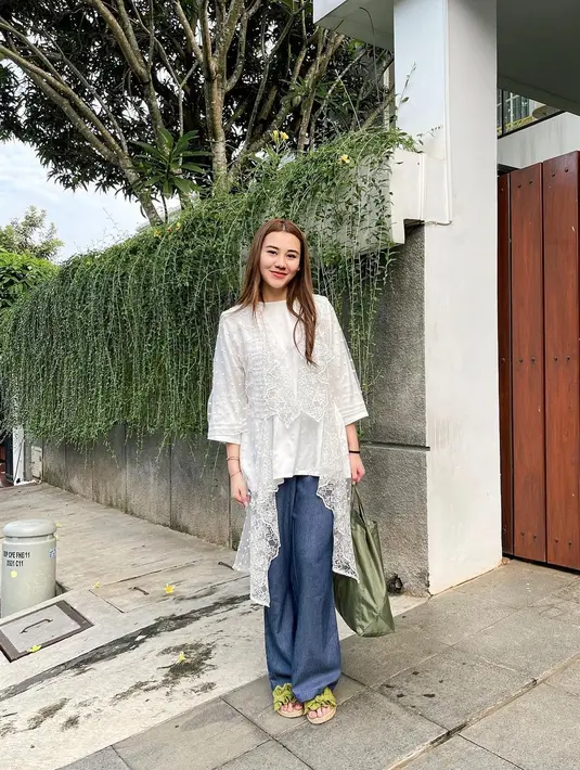 Gaya elegan Aaliyah Massaid saat merayakan Hari Raya Idul Adha. Ia mengenakan atasan putih yang cantik dipadu celana dengan siluet biru denim. [Foto: Instagram/aaliyah.massaid]