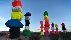 Seorang bocah memandangi instalasi seni yang berjudul ' Seven Magic Mountains' yang dibuat oleh seniman Swiss Ugo Rondinone di dekat Jean , Nevada, 14 Mei 2016. Karya seni berupa menara yang terbentuk dari tumpukan batu yang indah. (David Becker / AFP)
