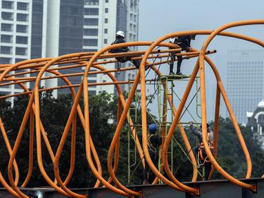 Aktivitas pekerja saat menyelesaikan pembangunan Sky Walk Kebayoran Lama, Jakarta, Selasa (11/10/2022). Jembatan penyebrangan orang (skywalk) ini dibangun untuk mendukung integrasi antarmoda transportasi. (Liputan6.com/JohanTallo)