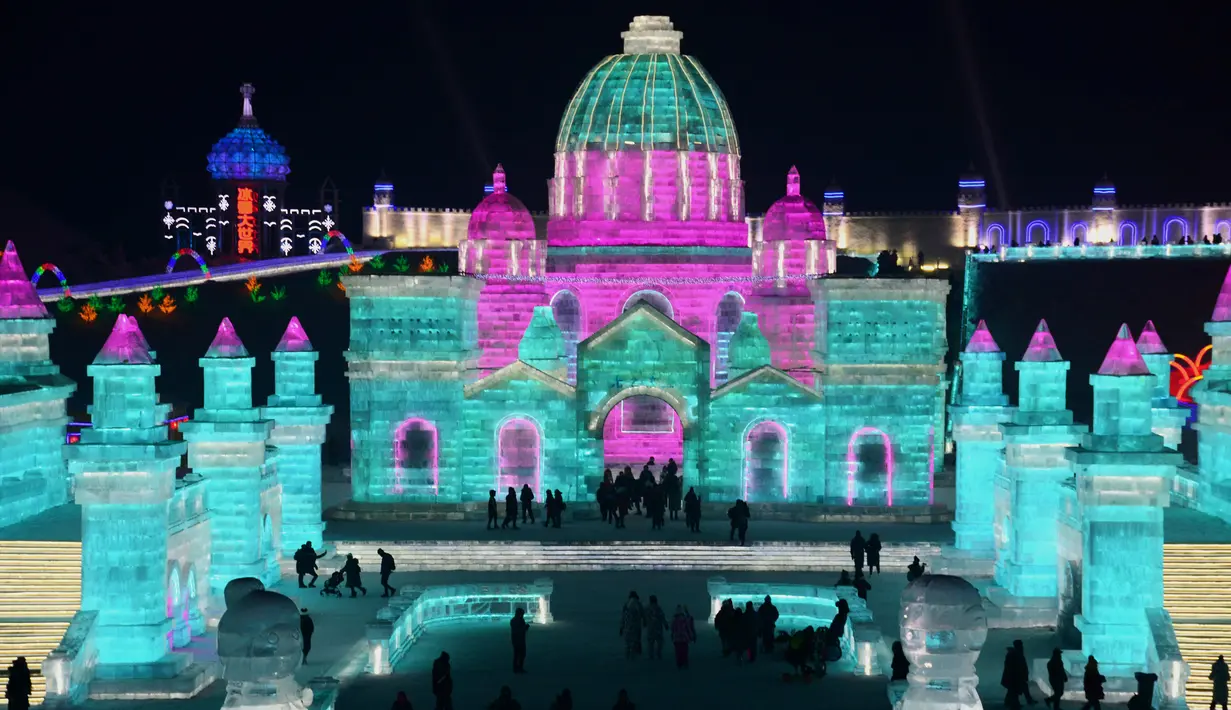 Sejumlah orang mengunjungi Harbin Ice-Snow World di Harbin di provinsi Heilongjiang, Tiongkok (2/1). Bangunan atau istana yang terbuat dari balok es ini dipenuhi cahaya yang berwarna-warni. (AFP Photo/China Out)
