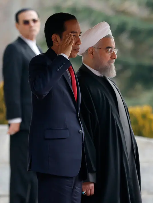 Presiden Joko Widodo bersama Presiden Hassan Rouhani saat mengikuti upacara penghormatan di Istana Saadabad, Rabu (14/12). Pemerintah Indonesia dan Iran sepakat meningkatkan kerja sama di bidang energi dan migas. (AFP Photo/Atta Kenare)