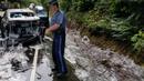Perwira polisi berada di lokasi kecelakaan sebuah truk pengangkut belut berlendir di jalan raya Highway 101, Oregon, Kamis (13/7). Truk yang membawa 3.402 kg belut lendir itu tak bisa menghentikan laju dan malah terguling. (Oregon State Police via AP)