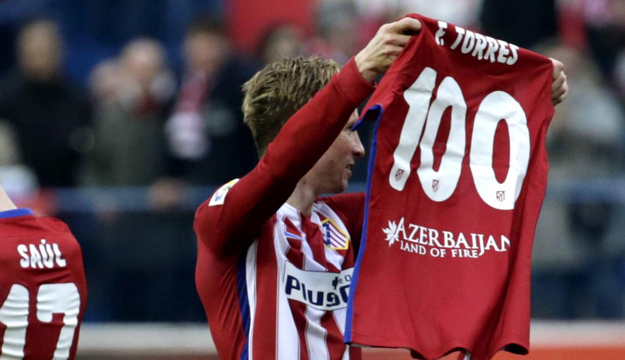 Pemain Atletico Madrid, Fernando Torres, mengangkat kaus bertuliskan 100 gol yang telah dicetaknya bersama Atletico Madrid pada lanjutan La Liga Spanyol di Stadion Vicente Calderon, Sabtu (6/2/2016). (EPA/Javier Lizon)