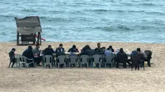 Warga Palestina berkumpul untuk berbagi makanan buka puasa selama bulan suci Ramadan, saat pandemi virus corona, di sepanjang pantai kota Gaza pada 13 Mei 2020. Mereka menunggu waktu berbuka puasa sambil menyaksikan matahari terbenam. (Photo by MAHMUD HAMS / AFP)