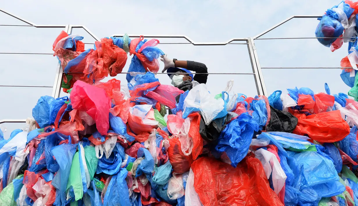 Relawan Nepal dan siswa sekolah membuat replika Laut Mati dari plastik daur ulang di Kathmandu pada 5 Desember 2018. Sebanyak 100.000 kantong plastik diikat di atas kisi besi dengan lebar 20 meter dan tinggi 5 meter. (PRAKASH MATHEMA / AFP)