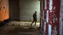 Seorang pria Yahudi bersenjata berjalan melalui deretan etalase toko yang ditutup untuk pemogokan umum yang menyerukan gencatan senjata di Gaza di Kota Tua Yerusalem, Senin (11/12/2023). (AP Photo/Maya Alleruzzo)