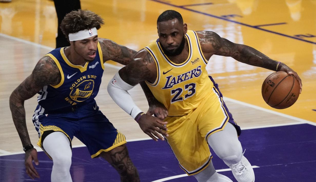 Pebasket LA Lakers LeBron James (kanan) berupaya melewati hadangan pebasket Golden State Warriors Kelly Oubre Jr. dalam pertandingan NBA di Staples Center,  Los Angeles, California, Amerika Serikat, Senin (18/1/2020). (AP Photo/Jae C. Hong)
