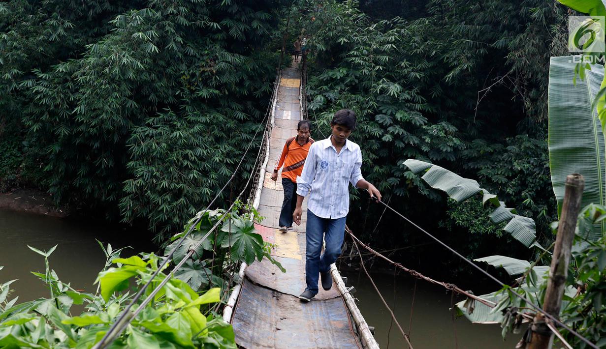 Warga melintasi jembatan penyeberangan buatan warga di kawasan Lenteng Agung, Jakarta, Rabu (24/5). Meskipun kondisinya memprihatinkan, warga setempat tetap menggunakan jembatan tersebut. (Liputan6.com/Immanuel Antonius)