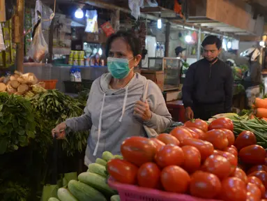 Seorang wanita yang mengenakan masker berjalan di Pasar Senen, Jakarta, Kamis (22/10/2020). Pedagang mengeluhkan sepinya pembeli karena terdampak pandemi COVID-19 serta ramainya demo Omnibus Law UU Cipta Kerja beberapa minggu ini. (merdeka.com/Imam Buhori)