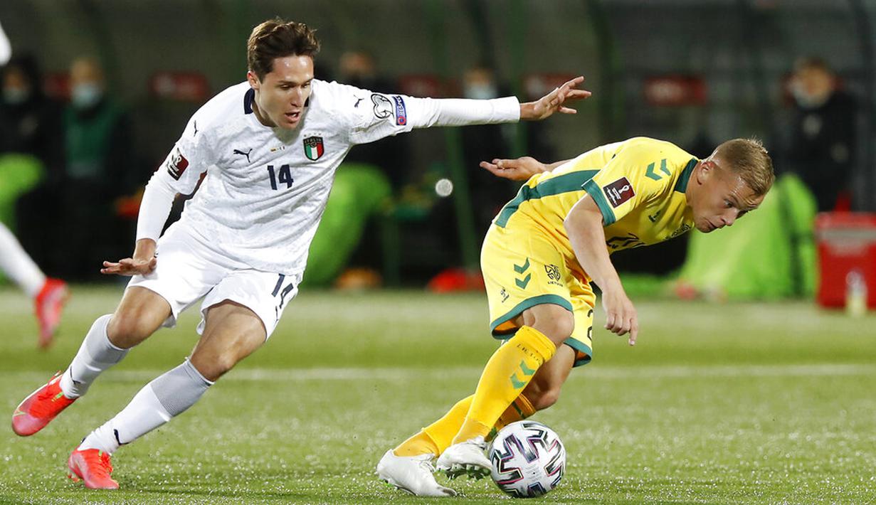 Pemain Italia Federico Chiesa (kiri) memperebutkan bola dengan pemain Lithuania Domantas Simkus pada pertandingan Grup C kualifikasi Piala Dunia 2022 di Stadion LFF, Vilnius, Lithuania, Rabu (31/3/2021). Italia menang 2-0. (AP Photo/Mindaugas Kulbis)