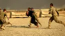 Tentara AS berlari membawa bola saat bermain American Football pada Thanksgiving di dalam pangkalan militer AS di Qayyara, selatan Mosul, Irak (24/141). (REUTERS/Thaier Al-Sudani)