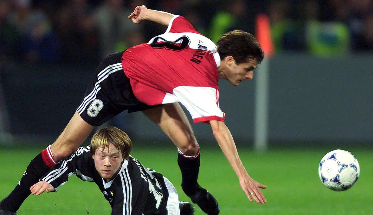 Bek tengah Feyenoord, Kees van Wonderen (atas) terjatuh saat perebutan bola dengan pemain Rosenborg Trondheim, Fredrik Wisnes pada laga fase grup Liga Champions 1998/1999 di Rotterdam (2/11/1999). Kees van Wonderen yang pensiun sejak Juli 2004, total hanya mengoleksi 5 caps bersama Timnas Belanda dan semuanya hanya di laga persahabatan. Saat ini ia dipercaya menjadi pelatih Heerenveen sejak 1 Juli 2022 hingga Juni 2024. (AFP/ANP/Jasper Juinen)