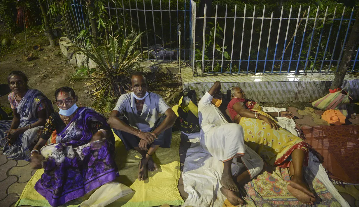 Warga bermalam untuk mendapatkan suntikan vaksin corona Covid-19 keesokan harinya di RSUD Siliguri, negara bagian Bengal Barat, India, Senin (20/9/2021). Sebanyak 202 juta orang India telah divaksin dua dosis atau lengkap hingga 19 September 2021. (Diptendu DUTTA/AFP)