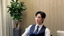 Gaya gentleman Kim Soo Hyun dibalut kemeja lengan panjang putih dan setelan vest dan celana panjang biru navy, ditambah dasi bernuansa senada. [Foto: Instagram/soohyun_k216]