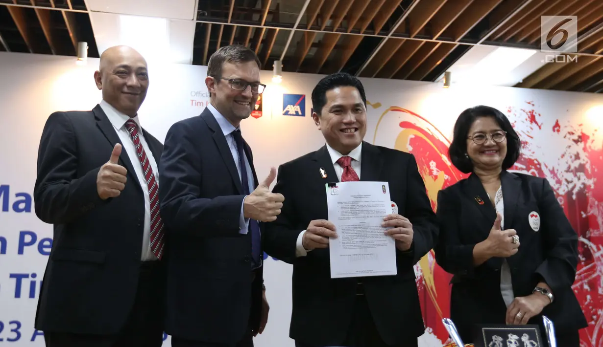 President Director of AXA Mandiri, Jean-Philippe Vandenschrick (kedua kiri) bersama Ketua Umum Komite Olimpiade Indonesia (KOI) Erick Thohir menujukkan berkas perjanjian kerja sama di AXA Tower, Jakarta, Senin (23/4). (Liputan6.com/Angga Yuniar)