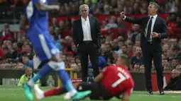 Manajer Leicester City Claude Puel (kanan) yang berdekatan dengan Manajer Manchester United Jose Mourinho (tengah) bereaksi atas keputusan wasit selama pertandingan Premier League Inggris di Old Trafford, Manchester, Jumat (10/8). (AP Photo/Jon Super)