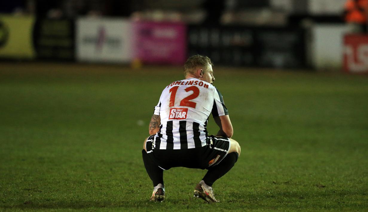 Gelandang Chorley, Willem Tomlinson tampak kecewa usai dikalahkan Wolverhampton Wanderers 0-1 dalam laga babak keempat Piala FA 2020/21 di Victory Park Stadium, Jumat (22/1/2021). (AFP/Lindsey Parnaby)