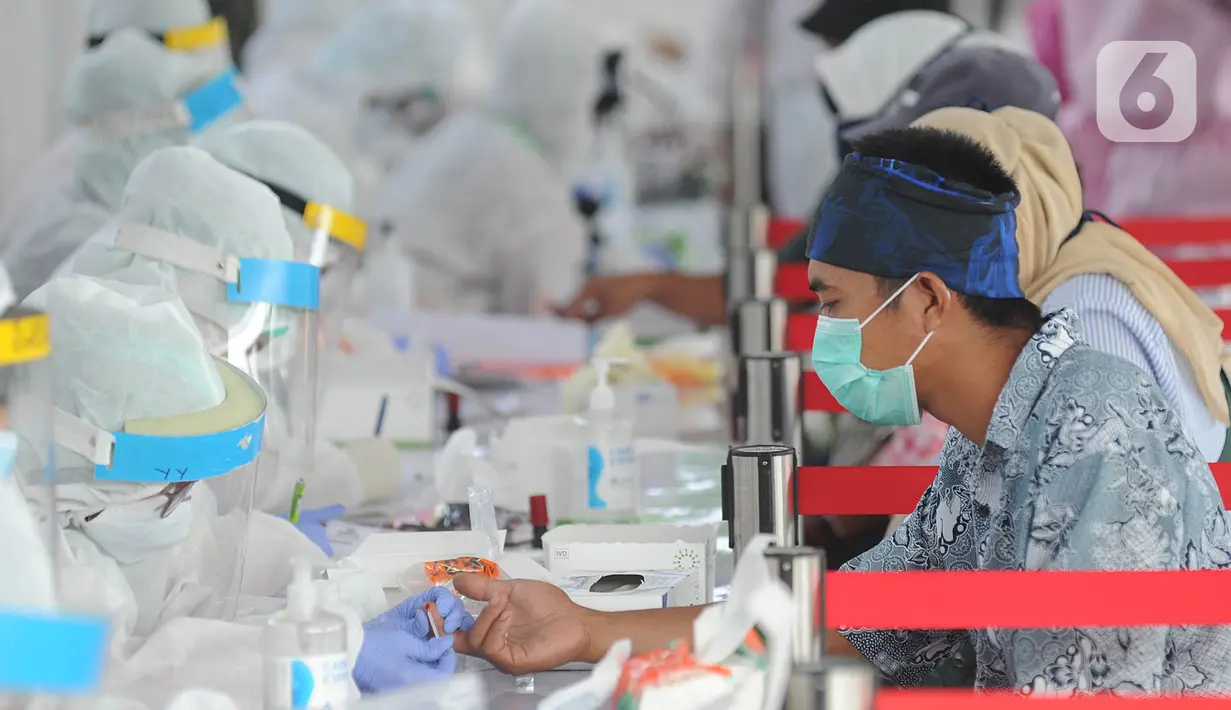 Petugas medis memeriksa warga saat rapid test oleh BIN di Lapangan Kantor Kecamatan Pamulang, Tangerang Selatan, Banten, Kamis (2/7/2020). BIN menggelar rapid test gratis terhadap 800 warga Pamulang untuk memutus mata rantai penyebaran virus corona COVID-19. (merdeka.com/Arie Basuki)
